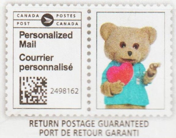 Teddy in a blue shirt holding a heart