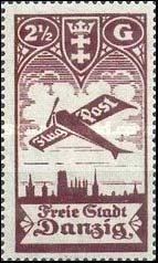 Airplane flying over the silhouette of the skyline of Danzig