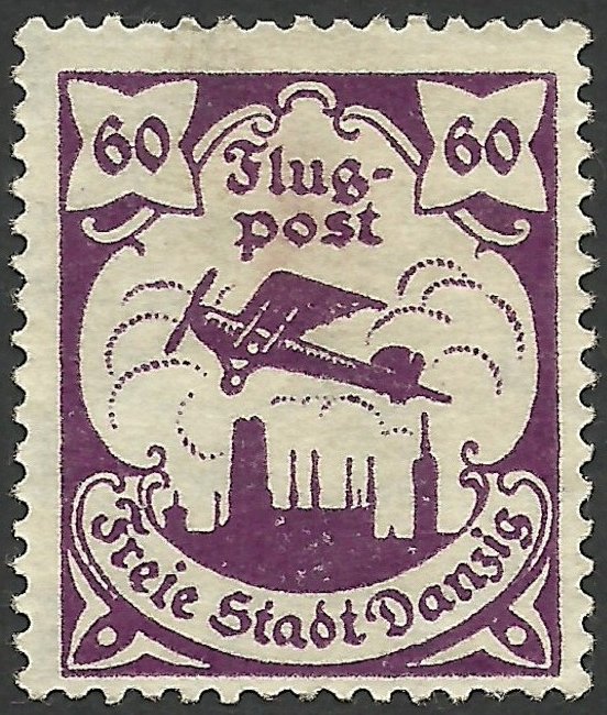 Airplane flying over the silhouette of the skyline of Danzig