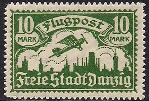 Airplane flying over the silhouette of the skyline of Danzig