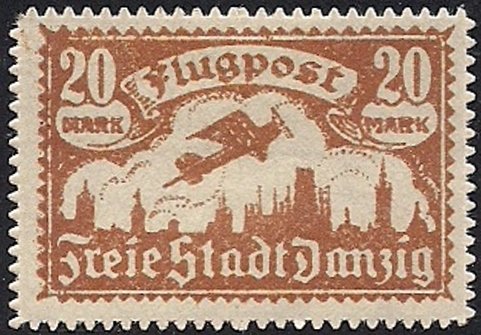 Airplane flying over the silhouette of the skyline of Danzig