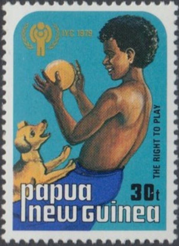 Boy playing with dog and ball