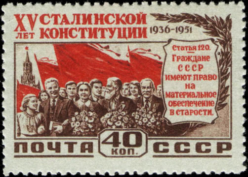 Трудящиеся на фоне красных знамен и Спасской башни Московского Кремля